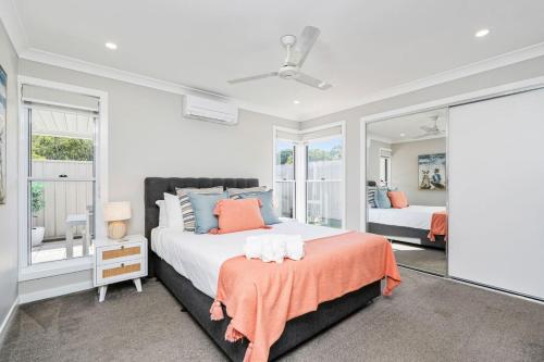 a bedroom with a large bed with an orange blanket at Family-friendly Seaside Gem in Urangan