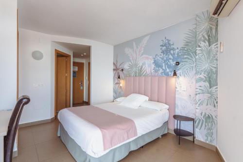 a bedroom with a bed with a pink headboard at Hotel Mainare Playa in Fuengirola