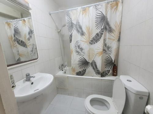 a bathroom with a toilet and a sink and a shower curtain at Majestic Room in Agadir