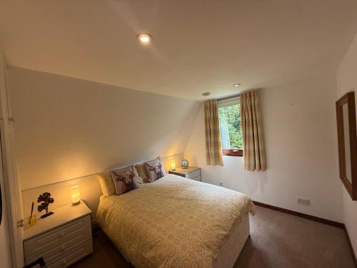 a bedroom with a bed and a window at Loch Oich Lodge in Invergarry