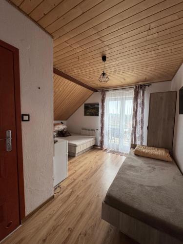 a large room with a bed and a large window at Pokoje u Joli Polańczyk in Polańczyk