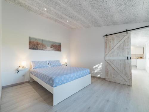 a bedroom with a bed and a sliding barn door at Winahost Pla de Can Sans in Sant Andreu de Llavaneres