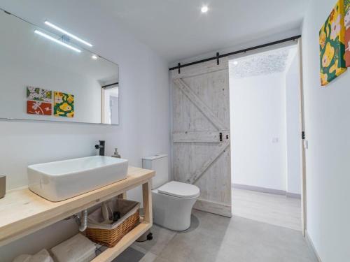 a bathroom with a white sink and a sliding barn door at Winahost Pla de Can Sans in Sant Andreu de Llavaneres