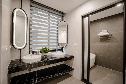 a bathroom with two sinks and two mirrors at Vui Hotel in Sầm Sơn