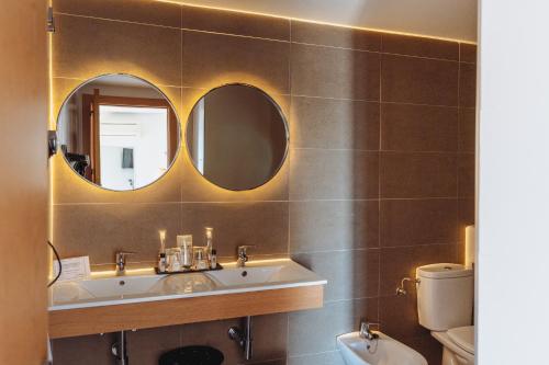 a bathroom with a sink and two mirrors at Hotel Mainare Playa in Fuengirola