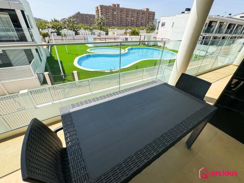 a table and chairs on a balcony with a swimming pool at Sun & Sea in Cabanes