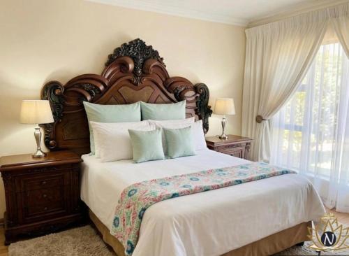a bedroom with a large bed with a wooden headboard at Nalana Guest House in Thaba Nchu