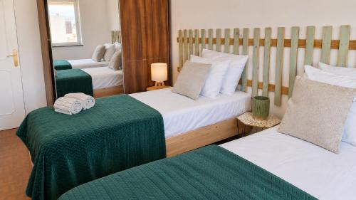a hotel room with two beds and a mirror at Maré Viva in Quarteira