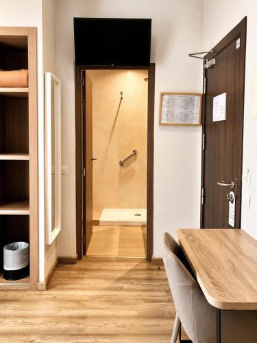 ein Badezimmer mit ebenerdiger Dusche und einer Tür mit Toilette in der Unterkunft Hostal Centric in Barcelona