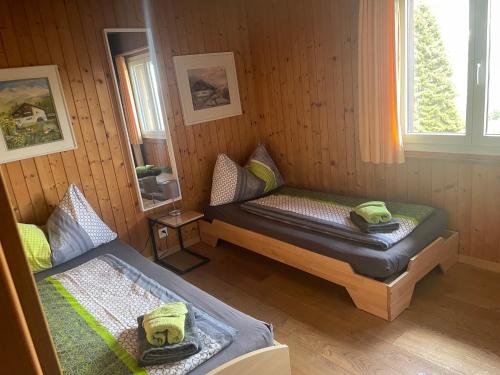 a room with two beds in a wooden cabin at Chalet Casa Cresta - Top of Lenzerheide - bis 9 Personen in Valbella