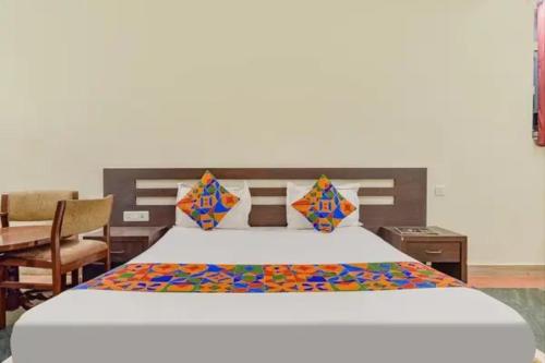 a large bed in a room with a table at FabHotel Jaipur Classic - Vaishali Nagar in Jāmb