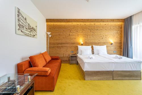 a hotel room with a bed and a couch at Hotel Kristály Konferencia & Wellness in Ajka
