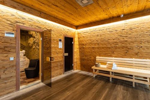 a wooden room with a bench and a door at Hotel Kristály Konferencia & Wellness in Ajka