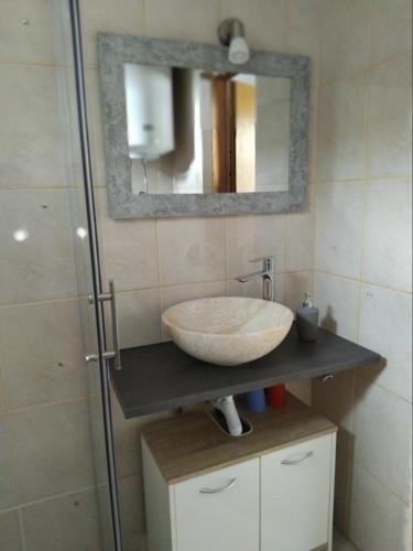 a bathroom with a sink and a mirror at Apartman "Vuković" in Bizovac