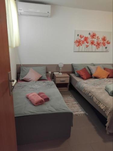 a room with two beds with pillows on them at Apartman "Vuković" in Bizovac