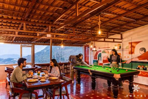 a group of people sitting around a pool table at Zostel Ooty, Pudumund in Ooty