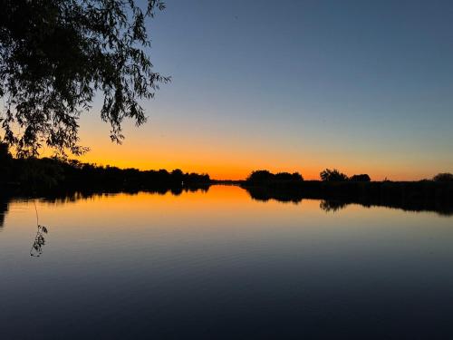 an image of a sunset on a lake at Waterside Cottage in Nagyrév