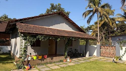 a small white house with a gazebo at Shanti Niketan in Kārwār