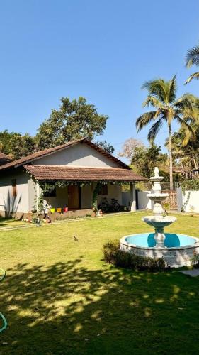 a fountain in a yard in front of a house at Shanti Niketan in Kārwār