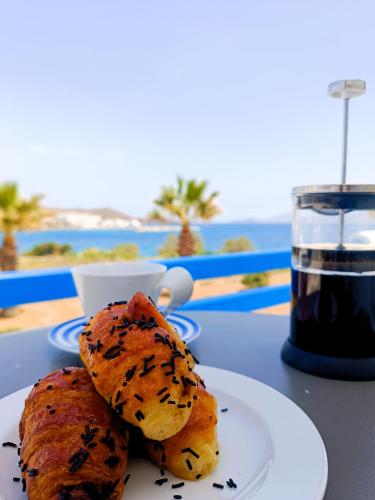 a plate of food on a table with a drink at Aura Paros in Logaras