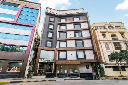 a tall building in the middle of two buildings at Treebo Address Inn, Banjara Hills in Hyderabad