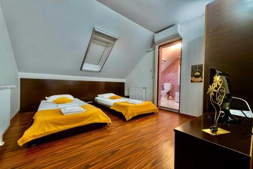 two beds in a large room with a bathroom at Pensiunea Gerard 2 Mai Camere Moderne cu baie privata, la 250 M de plaja ,Foisor, Parcare & WIfi Gratuit in 2 Mai