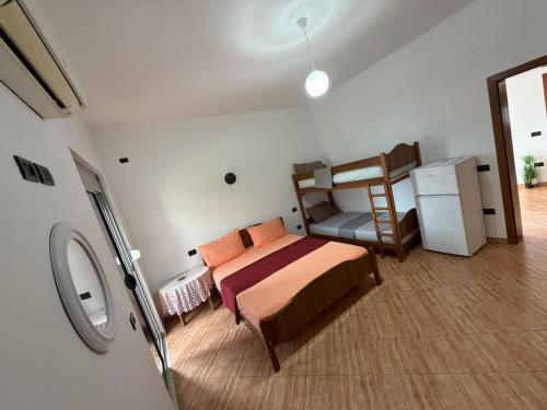 a small bedroom with a bed and a refrigerator at Vila Emanuele in Shëngjin