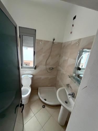 a bathroom with a toilet and a sink and a mirror at Vila Emanuele in Shëngjin