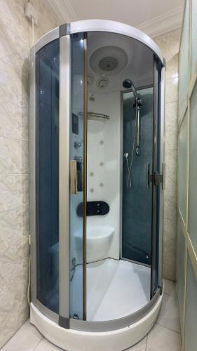 a bathroom with a shower with a glass door at Wenggies Apartment in Abuja