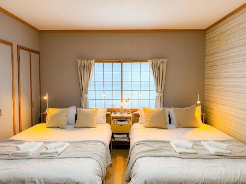 a bedroom with two beds and a living room at Shirakaba in Otaru