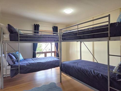 two bunk beds in a room with a window at Milliana House in Wallaroo