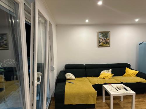 a living room with a black couch and a table at Apartments Daisy in Banja Luka