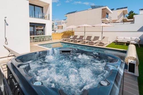 a hot tub in the backyard of a house at Paradise Villa Sky - Signature by Paradise Portugal in Ribamar