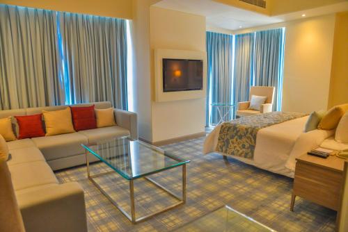 a hotel room with a bed and a couch at Efcee Sarovar Premiere Bhavnagar in Bhavnagar
