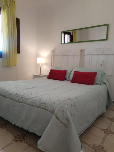 a bedroom with a white bed with red pillows at Chalet Garcia in Deltebre