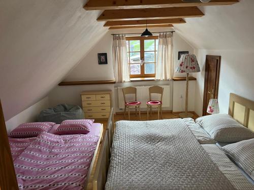 a attic bedroom with three beds and a window at Chalúpka Barborka in Lúčky