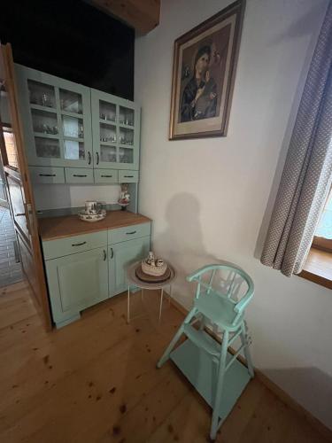 a kitchen with a blue chair and a table at Chalúpka Barborka in Lúčky