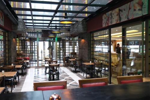 a restaurant with tables and chairs and windows at Boris Hotel Istanbul Beylikduzu in Beylikduzu