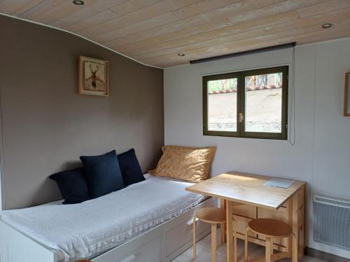 a small bedroom with a bed and a table at la cabane des remparts in Marsac-en-Livradois