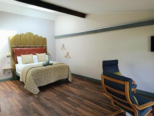 a bedroom with a bed and a chair at Lodge Two The Old Gasworks in Milverton