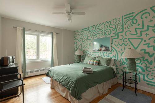 a bedroom with a bed with green and white wallpaper at #Le80ies - Downtown Rooftop - Free shuttle to ski Mountain in Mont-Tremblant