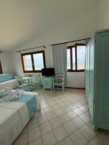 a bedroom with a bed and a table and chairs at La Locanda del Mare in Codaruina