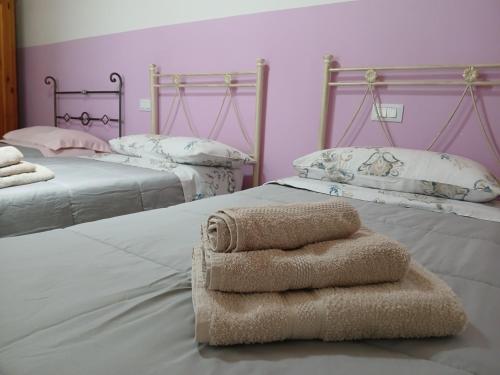 two beds with towels on them in a room at Le stanze di NinFa in Pacentro