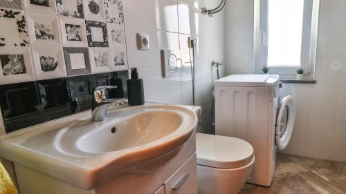 a bathroom with a sink and a toilet at Sonnengarten floor 1 in Marčana