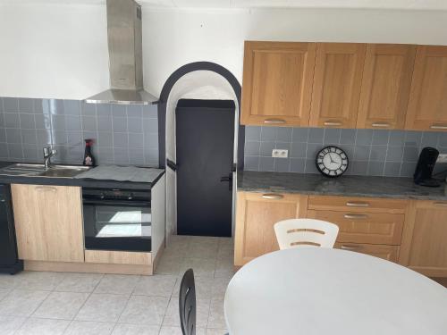 a kitchen with wooden cabinets and a sink and a table at Maison de pêcheurs in Trégunc