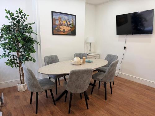 a dining room with a table and chairs at The Cosy Nest Modern - 3BR House - Sleeps 7 - Near City Centre - STARLINK Wi-fi in Liverpool