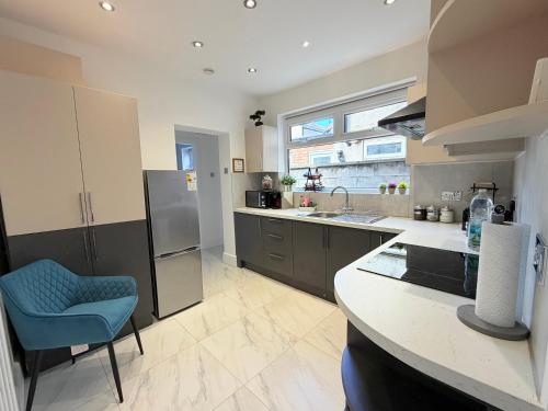 a kitchen with a counter and a blue chair in it at The Cosy Nest Modern - 3BR House - Sleeps 7 - Near City Centre - STARLINK Wi-fi in Liverpool