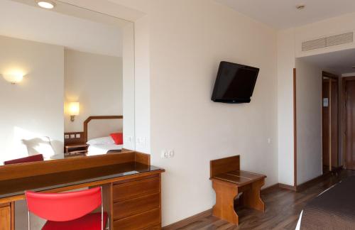 a hotel room with a tv on a wall at Senator Barajas in Madrid