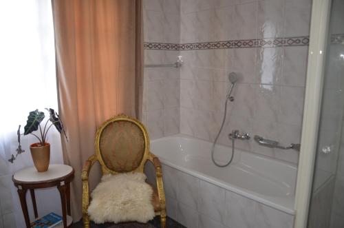 a bathroom with a tub and a chair next to a shower at Auszeitloge in Nottwil