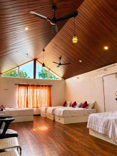 a bedroom with two beds and a ceiling fan at Sunset Villa by Hyatt Stay in Avathi